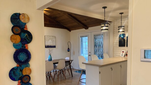 Une cuisine moderne avec un plafond en bois, des armoires blanches et un îlot central.