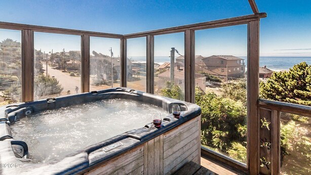 Ein Whirlpool auf einem Balkon mit Blick auf eine Wohngegend und das Meer.