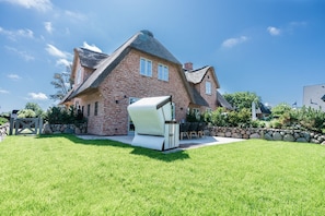 A brick house with a thatched roof, a stone wall, and a grassy yard. - Loddis Hüs - Loddi's Hüs (Wenningstedt-Braderup (Sylt))