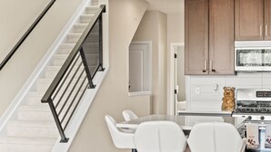 Une cuisine moderne équipée d’une cuisinière Bosch, d’un meuble en bois et d’un plan de travail blanc.