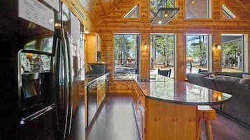 A modern log cabin interior with a kitchen, bar area, and seating.