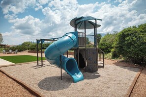 Un parque infantil con tobogán y estructuras para escalar.