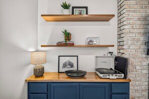 A kitchen counter with a coffee machine, a framed picture, and a lamp. - Hummingbird House - 2 King Beds, Mountain Views & Fire Pit (Sierra Vista)