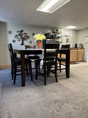 A dining area with a table and chairs, a vase with flowers, a microwave, and a coffee maker on the counter. - Private Large Suite, cozy, quiet & close to I-75 (Lebanon)
