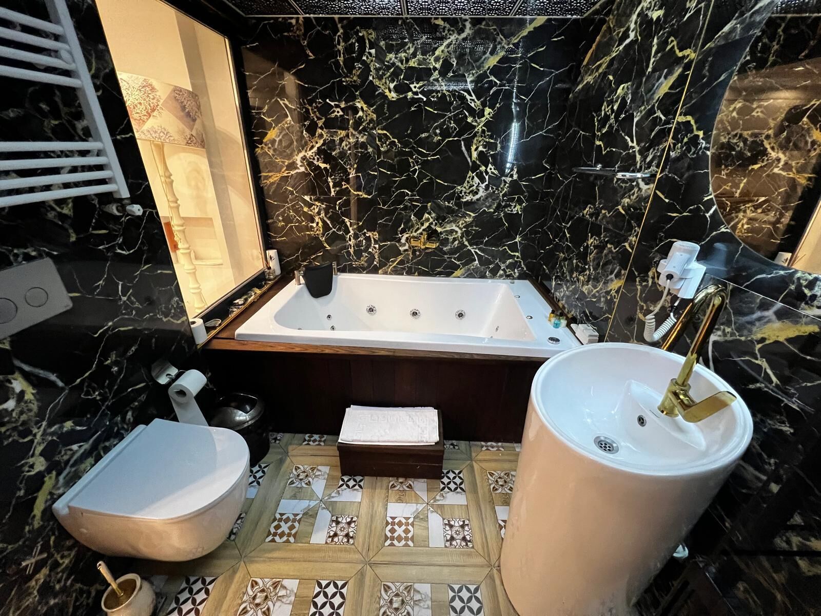 A bathroom with a marble sink, a bathtub, and a bidet.