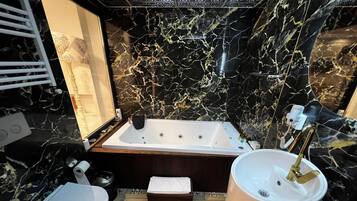 A bathroom with a marble sink, a bathtub, and a bidet.