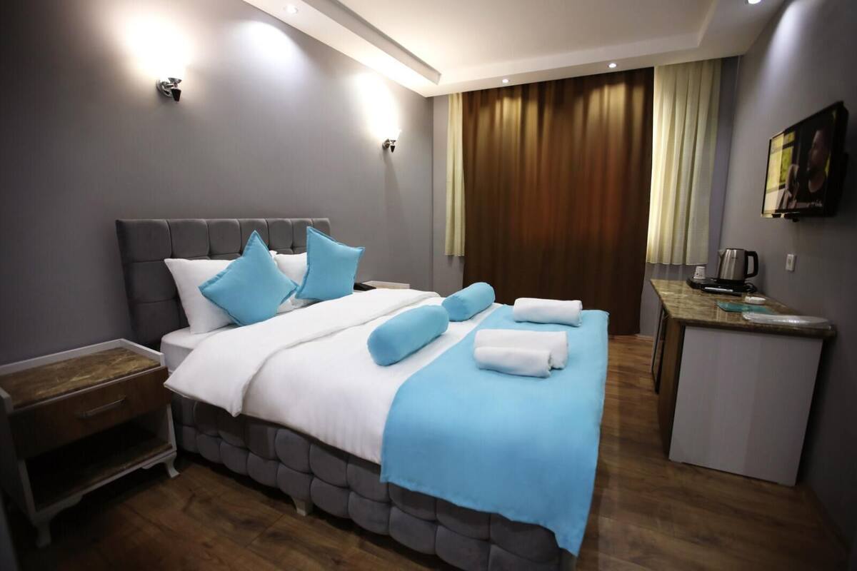 Una habitación de hotel moderna con una cama grande, un escritorio pequeño y un baño.