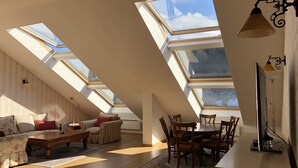 A spacious loft with skylights, a dining area, and a cozy seating area. - Luxury 2BR Penthouse in an elegant hotel with lavish SPA & Heated Swimming Pool (Bansko)