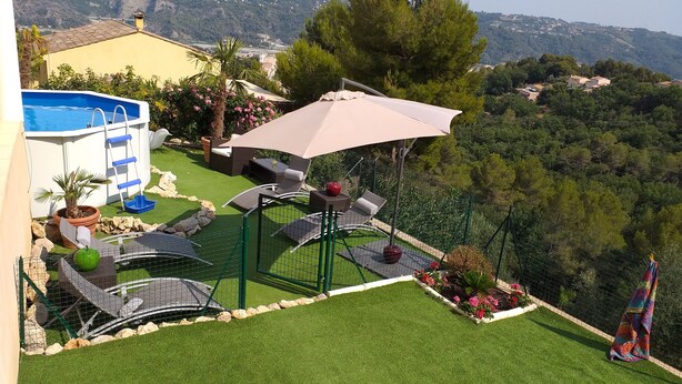 A backyard with a pool, outdoor furniture, and a view of the surrounding hills. - Superbe 3P dans villa avec vue mer et collines (Carros)