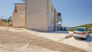 A two-story building with a balcony, a car parked in front, and a clear sky. - 2 bedroom amazing apartment in Vinisce (Vinisce)