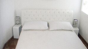 A bed with a tufted headboard, two white pillows, and two bedside tables with decorative silver elements. - 2 bedroom amazing apartment in Vinisce (Vinisce)