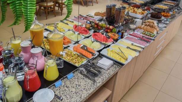 Un bufé con diversas opciones de comida, incluyendo frutas, verduras y bebidas.