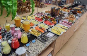 A buffet with a variety of food options including fruits, vegetables, and beverages. - Hotel Plaza Garden (Cascavel)