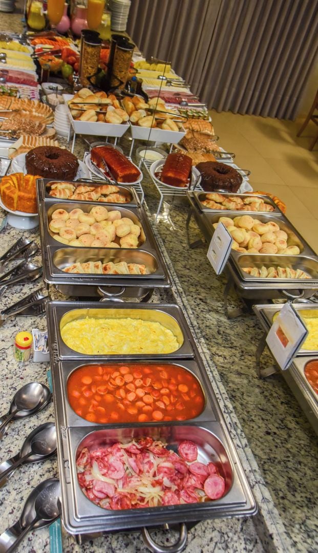 Un bufé con diversas opciones de comida, incluyendo carnes, quesos y productos de panadería.