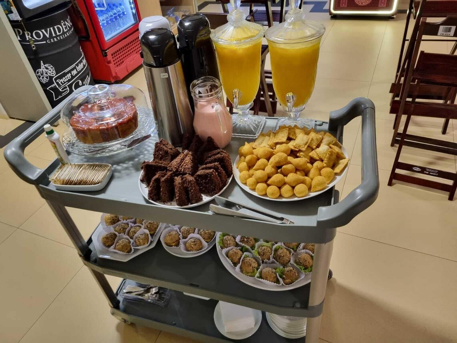 Un carro de buffet con distintos tipos de comida, incluyendo pasteles, brownies y aperitivos.