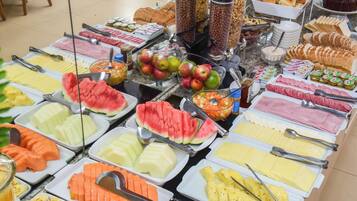 A buffet with various food items including fruits, vegetables, and meats.