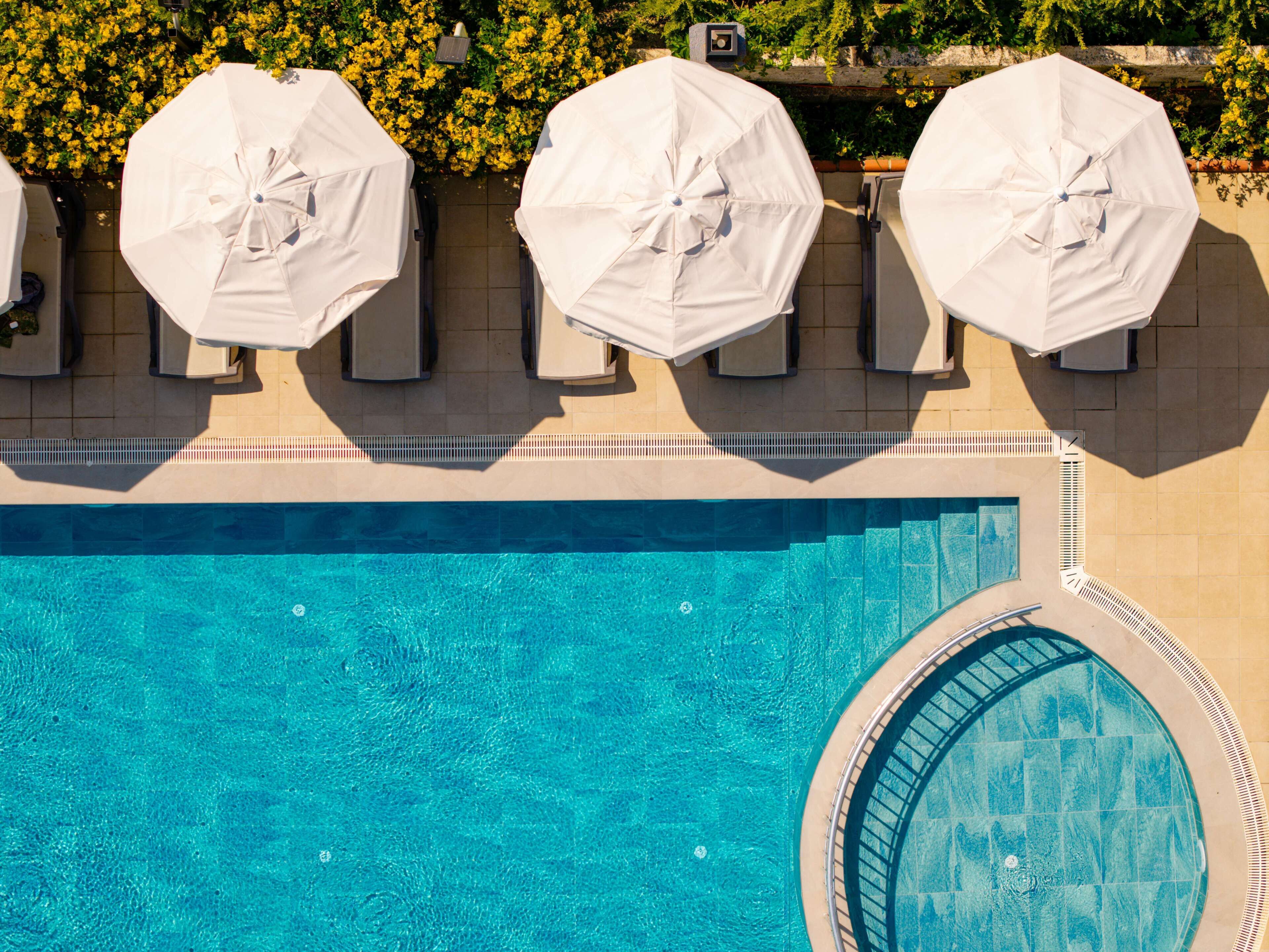 Seasonal outdoor pool, open 8:00 AM to 7:00 PM, pool umbrellas