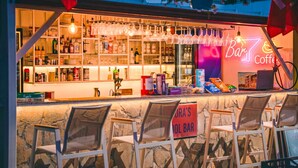 A bar with a neon sign, shelves with bottles, and chairs. - Nora Suit Hotel (Manavgat)