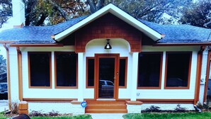 A single-story house with a front porch, a mailbox, and a driveway leading to the entrance. - The Le Chic Bungalow (Decatur)