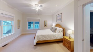A bedroom with a bed, a nightstand, a ceiling fan, and two windows with blinds. - Wonderful Main Street Location, next to the HS Historical Society! (Harbor Springs)