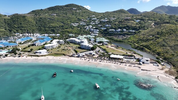 An aerial view of a coastal resort with multiple buildings, a beach, and boats. - spacious appartment facing the sea with private garden jaccuzi and plancha grill (Saint Martin)