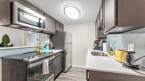 Une cuisine moderne équipée d’appareils électroménagers en acier inoxydable, d’un four à micro-ondes et d’un four encastré.