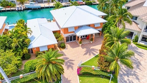 A multi-story building with a swimming pool, surrounded by palm trees and a well-maintained garden. - Key Colony Beach Rentals, Fl, Boat Dock, Sleep 10 - 5 Bedrooms, Waterfront, Pool (Key Colony Beach)