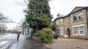 A residential street with houses, a parked car, and a pedestrian crossing.