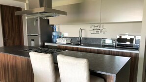 A modern kitchen with a central island, stainless steel appliances, and a word cloud on the wall. - Luxury apartment in Acapulco diamond (Acapulco de Juárez)
