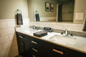 A bathroom with two sinks, a mirror, and a towel rack. - Spacious basement with brand new kitchen (Cheyenne)