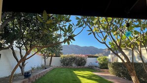 Ein gepflegter Garten mit Rasen, Bäumen und Bergblick.