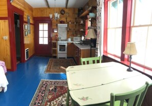 Cozy room with a dining table, kitchen area, and large window.