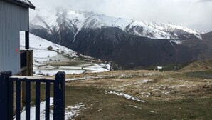 Paisaje montañoso con un edificio en primer plano.