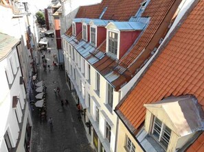 Una calle estrecha flanqueada por edificios con tejados rojos y empedrada.