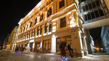 Ein historisches Gebäude mit klassischer Architektur, eine gepflasterte Straße und ein Fahrrad davor.