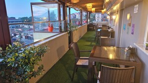 A terrace with outdoor seating, a view of the city, and artificial grass. - Pointbreak Hotel (Trabzon)