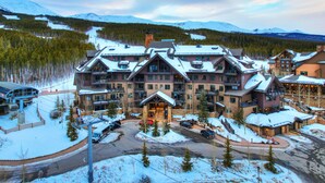 A large lodge with multiple balconies and a ski slope in the background. - Peak 7 Ski In Ski Out, 1 bedroom condo Breckenridge. Next to the Super Chair (breckenridge)