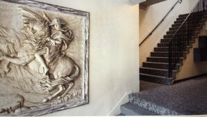 A staircase with a metal railing and a patterned carpet.