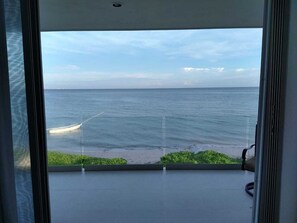 Uma varanda com vista para o oceano e a praia.