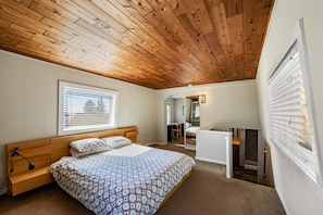 Relax in a spacious bedroom with a large bed, desk, and mirror.