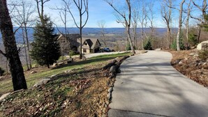 A residential area with a paved driveway leading to a house with a stone facade and a garage. - Spectacular bluff views facing west.  Magnificent sunsets! (Lookout Mountain)
