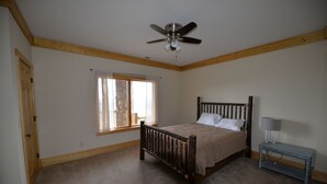 A bedroom with a wooden bed, a ceiling fan, a window with curtains, and a bedside table with a lamp. - Spectacular bluff views facing west.  Magnificent sunsets! (Lookout Mountain)