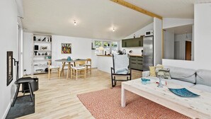 Un espace de vie moderne comprenant un coin repas, une cuisine et un coin salon.