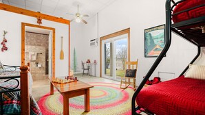 A cozy room with a bunk bed, a wooden table, a colorful rug, a chessboard, and a poster on the wall. - Lake Travis Waterfront LUX/Dock/Firepit/Outdr play (Lago Vista)