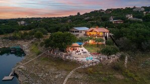A large house with a patio and pool, surrounded by trees and a lake. - Lake Travis Waterfront LUX/Dock/Firepit/Outdr play (Lago Vista)