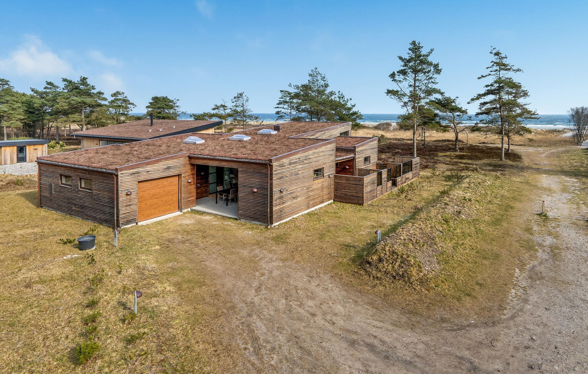 A modern house with a flat roof, large windows, and a garage.