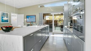 A modern kitchen with a large island, stainless steel appliances, and a view to the outdoors. - Stunning home in Hals with sauna (Hals)