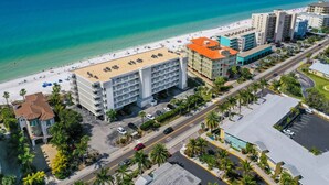 Un hôtel avec vue sur la plage, plusieurs étages et un parking.
