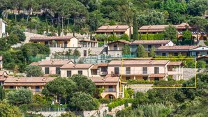A hillside residential area with terraced houses, some with balconies, surrounded by greenery. - 1 bedroom beach front apartment in Nisportino (Nisportino)
