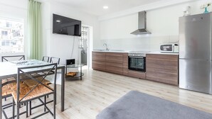 A modern kitchen with a dining area, featuring a flat-screen TV, stainless steel appliances, and a view of the city. - Gorgeous apartment in Santa Pola with WiFi (Santa Pola)